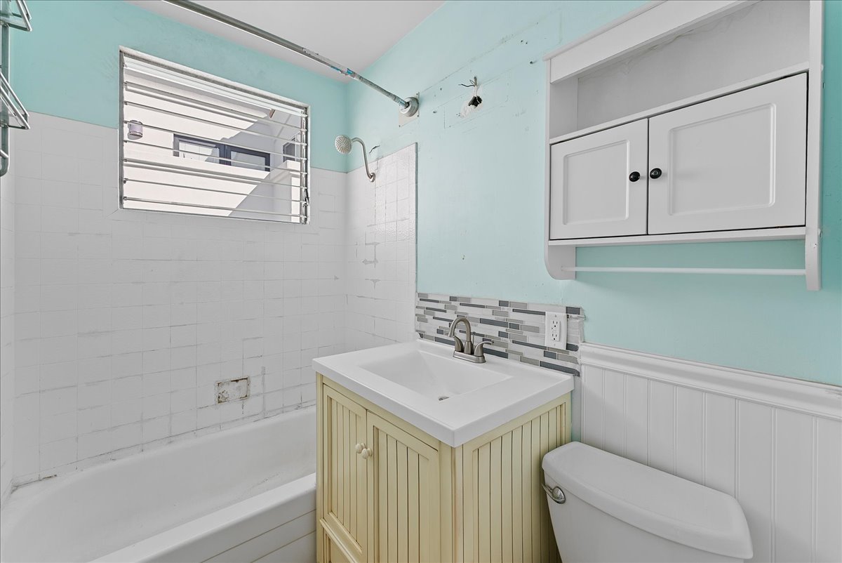 Before: Bathroom before renovation with tile tub surround