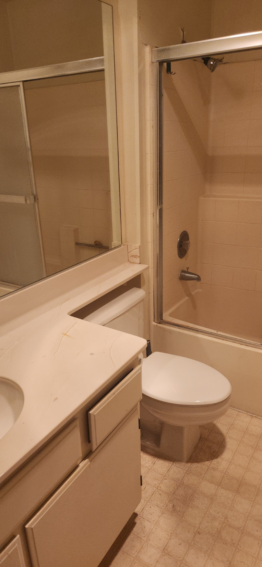 Before: Bathroom before renovation with dated vanity and tile tub surround