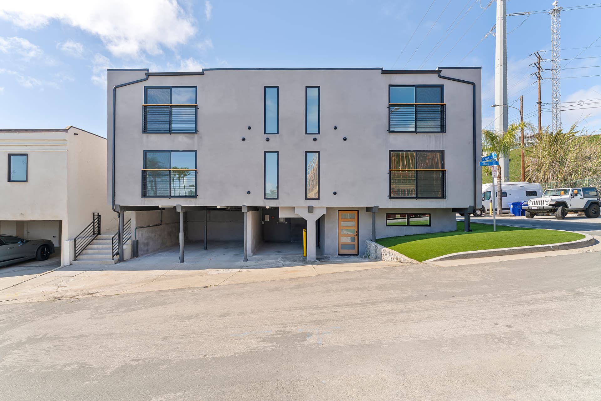 After: Renovated front of the Crest Dr building with new exterior finish, black-trimmed windows and finished landscaping